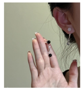 Gros plan de boucles d'oreilles en argent S925 avec des perles bicolores minimalistes