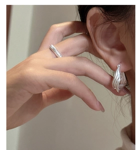 Detail of S925 sterling silver hoop earring with vertical texture on model ear