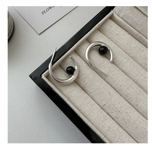 Detailed close-up of S925 silver C-shape earrings with inlaid black onyx on velvet