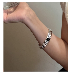 Detail eines gehämmerten S925 Silberarmbands mit einem runden schwarzen Onyx-Stein