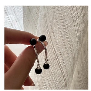 Gros plan sur des boucles d'oreilles pendantes en argent S925 avec perles d'agate noire