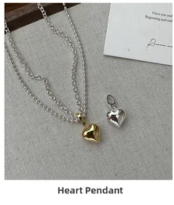 Detail shot of heart-shaped pendants in gold and silver on premium linen background