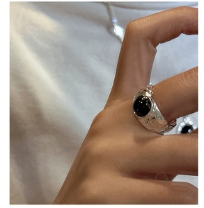 Nahaufnahme von Silberring mit Hammerschlag-Textur und großem runden schwarzen Onyx