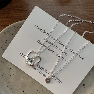 Polished S925 sterling silver heart necklace with hollow twist knot pendant on a card