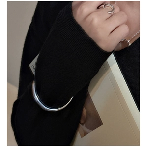 Primo piano del bracciale rigido e dell'anello a ferro di cavallo in argento lucido