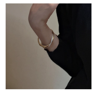 Dettaglio del bracciale rigido tricolore intrecciato in oro, argento e oro rosa