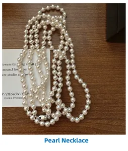 Detail of multi-layered S925 silver long necklace with lustrous white pearls on wood surface