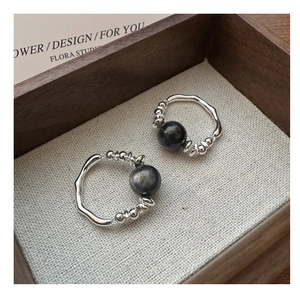 Macro detail of S925 sterling silver rings with black gemstones on a linen tray