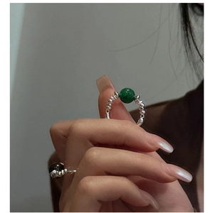 Detailed view of silver beaded rings with green agate and black obsidian gemstones