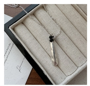 Detailed view of S925 silver water drop pendant with black beads in a gift jewelry box