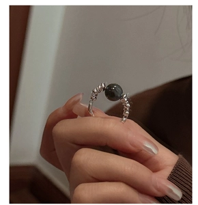 Detail of S925 sterling silver beaded ring with a dark pearl shown on a model hand