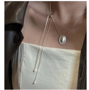 Dettaglio della collana in argento sterling S925 con pendente ovale opaco e nappe lunghe sottili