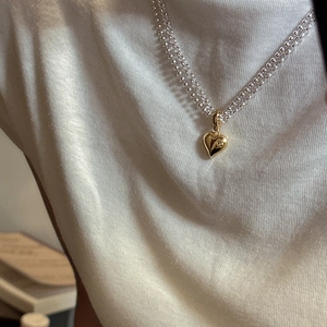 S925 sterling silver layered necklace featuring a polished gold heart pendant on models neck