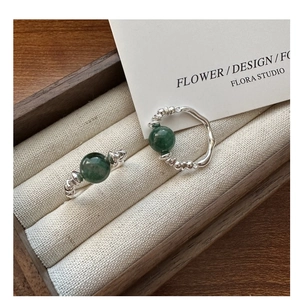 Detail of silver rings with green jade beads and handcrafted hammered texture details
