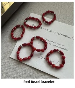 Set of red beaded rings with silver accents on a minimalist vintage display card