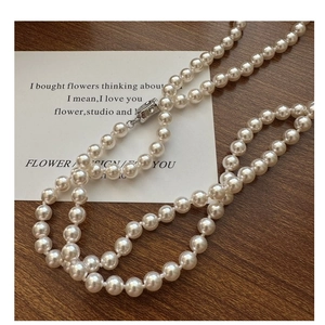 Detailed macro view of S925 silver pearl necklace on vintage wooden background