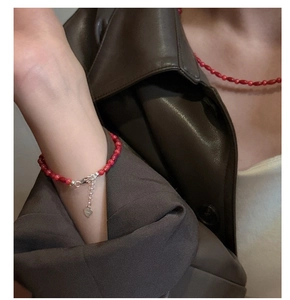 Detail of red agate bead bracelet with S925 sterling silver heart charm and extension chain