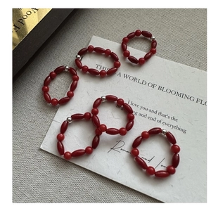 Detailed view of red beaded rings set with silver accents on a minimalist background