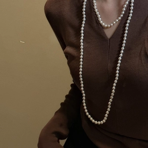 Elegant layered S925 sterling silver long pearl necklace on a brown V-neck sweater
