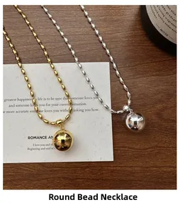 Detail of beaded ball necklaces in gold and silver finish on a rustic wooden table