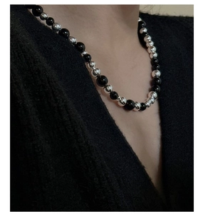 Détail d'un collier de perles alternant onyx noir et perles rondes en argenté