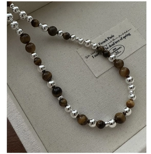 Vue macro du fermoir OT en argent S925 et perles marron dégradées sur le collier