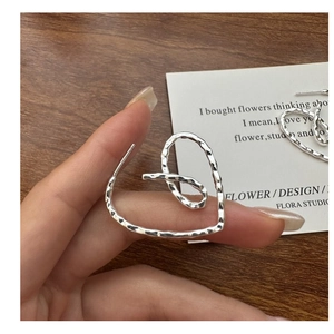 Macro shot of S925 silver heart earring with hammered texture and vintage finish