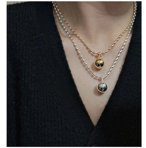 Close-up of gold and silver S925 sterling silver necklaces with smooth ball pendants