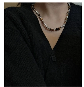 Détail du collier S925 avec fermoir OT et perles œil de tigre porté par un mannequin