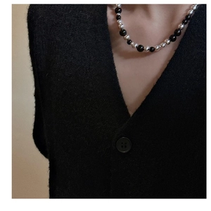 Gros plan du collier minimaliste en perles d'onyx noir et argent sur le cou