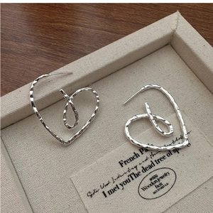 Detailed view of handmade S925 sterling silver heart earrings with hammered texture