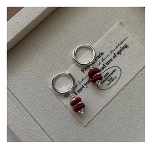 Detail of S925 silver vintage earrings with red velvet cylinders on fabric card