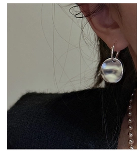 Macro detail of silver S925 earrings with unique pleated texture and vintage industrial look