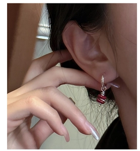 Detail of S925 silver earring with red stone and wire wrap on model's ear