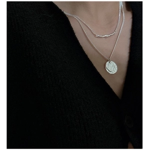 Close-up of double-layered S925 silver necklace with curve and coin pendants on model