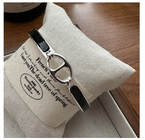Gros plan du bracelet en argent S925 avec émail noir et boucle groin sur coussin