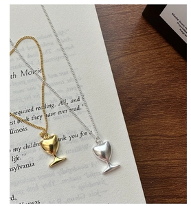 Détail des pendentifs calice en argent S925 en finitions or et argent sur un livre