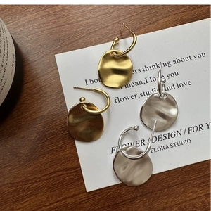 Detailed macro view of S925 sterling silver stamp on wrinkled texture dangle earrings