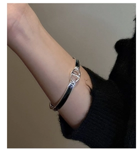 Vue détaillée d'un bracelet jonc en argent S925 avec motif nez de cochon en émail noir au poignet