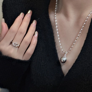 S925 sterling silver bead necklace and hollow geometric ring set on black sweater