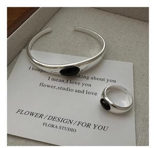 Detail of silver S925 ring and bangle set featuring oval black agate on a display tray