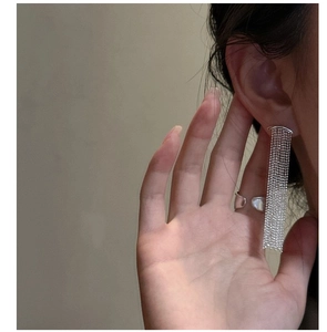Dettaglio degli orecchini a nappa in argento S925 e anello minimalista indossati da modella