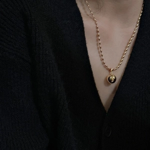Minimalist S925 sterling silver gold ball pendant necklace worn on a black cardigan