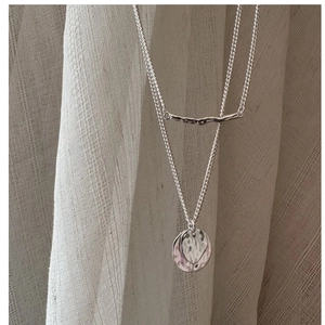 Close-up of S925 silver double-layered necklace with hammered disc and bar pendants