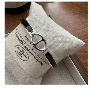 Détail du bracelet groin de porc en argent avec émail noir sur coussin beige