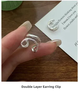 Detail of minimalist S925 sterling silver double-layer ear cuff shown on a finger