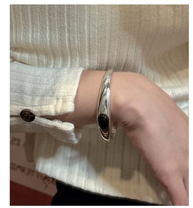 Close-up of polished S925 sterling silver cuff bracelet featuring an oval black agate stone