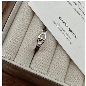 Détail macro d'une bague ancre en argent avec émail noir dans un coffret à bijoux