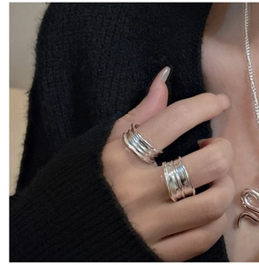 Close-up of minimalist S925 sterling silver stacked rings with irregular wave texture