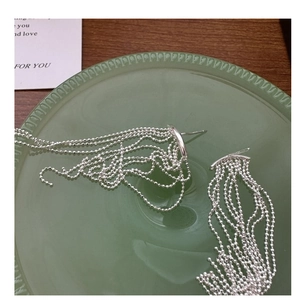 Vista dettagliata degli orecchini a nappa in argento S925 con catenine di perle
